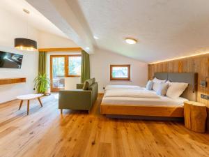 a bedroom with a large bed and a chair at Familienchalet Kitzblick in Kaprun