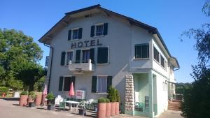 un bâtiment blanc avec un panneau indiquant l'hôtel dans l'établissement Hotel de la Gare, Vendlincourt, à Vendlincourt