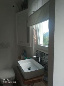 bagno con lavandino bianco e finestra di Casetta di Lisa in Valle Cervo a Campiglia Cervo