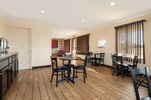 a dining room with tables and chairs and a kitchen at Red Roof Inn Santee in Santee