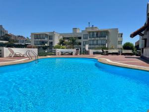 a large blue swimming pool in front of a building at Departamento Holiday Park Reñaca 306 Familiar in Viña del Mar