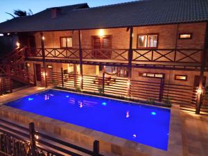 a swimming pool in front of a house at night at BEACH HOUSE - Loggia Suite 3 - com cozinha - na praia - BEACHFRONT in Barra Grande