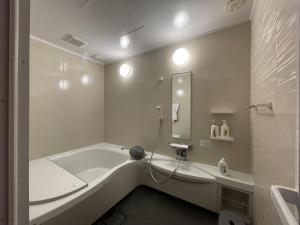 uma casa de banho com uma banheira, um lavatório e um espelho. em IHOKI BASE - Vacation STAY 57543v em Kumano