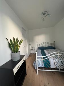 ein Schlafzimmer mit einem Bett und einer Kommode in der Unterkunft Les Studios Parfaitement Imparfaits - Lens Louvre-Bollaert in Lens