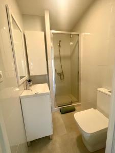 een witte badkamer met een douche en een toilet bij Arenales del sol, primera linea de playa in Arenales del Sol