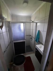 a small bathroom with a shower and a sink at Cabaña Buena Madera in San Vicente