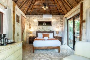 a bedroom with a bed and a stone wall at Yayum Bacalar in Bacalar