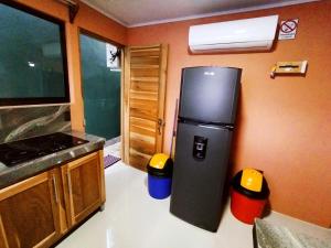 a kitchen with a refrigerator and two trash cans at Arenal Palacios in Fortuna