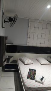 a bed with a book on it in a room at Hotel Progresso in Curitiba