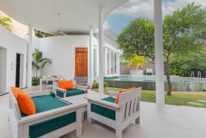 eine Außenterrasse mit Stühlen und einem Pool in der Unterkunft Taman Mesari Luxury Villas-Seminyak in Seminyak