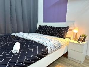 a bed with a black and white comforter in a bedroom at Beautiful Double Partition Room in Tecom Near ICM Metro in Dubai