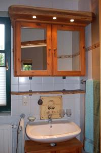 ein Badezimmer mit einem Waschbecken und einem Holzschrank in der Unterkunft Apartment in Sehlen/Insel Rügen 3075 in Sehlen