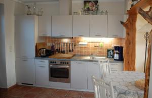 a kitchen with white cabinets and a stove top oven at Apartment in Sehlen/Insel Rügen 3075 in Sehlen