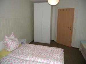 ein Schlafzimmer mit einem Bett mit einer rosa Decke und Kissen in der Unterkunft Holiday home in Bergen/Insel Rügen 2847 in Bergen auf Rügen