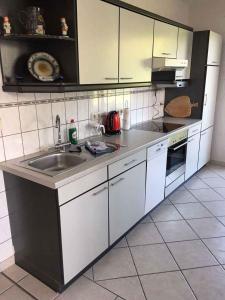 eine Küche mit weißen Schränken und einem Waschbecken in der Unterkunft Holiday home in Bergen/Insel Rügen 2847 in Bergen auf Rügen