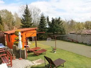 un patio trasero con un cobertizo de color naranja y una pista de voleibol en Holiday home in Skrdlovice 1383 en Škrdlovice