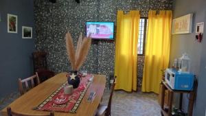 a dining room with a wooden table and a tv at Dani I in Jesús María