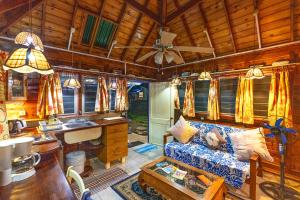 a living room with a couch and a ceiling at Heimanarii's Lodge - Fare Miti in Haapiti