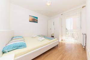 ein weißes Schlafzimmer mit einem Bett und einem Fenster in der Unterkunft Apartments with a parking space Kastel Luksic, Kastela - 22071 in Kaštela