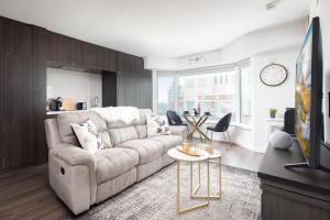 ein Wohnzimmer mit einem Sofa und einem Tisch in der Unterkunft Luxury Apartment in Yorkville Downtown Toronto with City View in Toronto