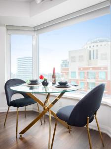 einen Tisch und zwei Stühle in einem Zimmer mit Fenster in der Unterkunft Luxury Apartment in Yorkville Downtown Toronto with City View in Toronto