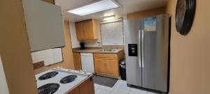 Cozy Condo For Rent In Melbourne Florida في ملبورن: مطبخ صغير مع ثلاجة وموقد