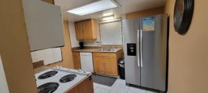 cocina pequeña con nevera y fogones en Cozy Condo For Rent In Melbourne Florida, en Melbourne