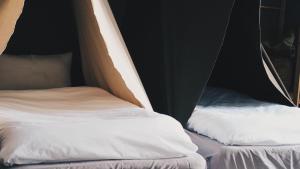 duas camas numa tenda com lençóis brancos em 小帳篷 em Hengchun Old Town