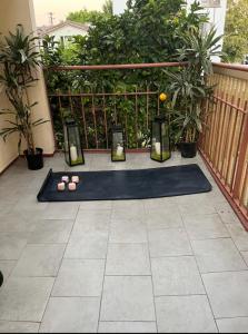 a black yoga mat with candles and plants on a balcony at Beautiful Beverly Hills Townhome in Los Angeles