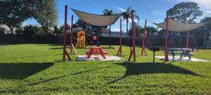 a playground with a swing set in a park at Cozy Condo For Rent In Melbourne Florida in Melbourne