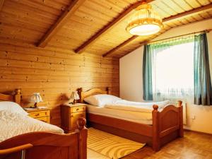 1 dormitorio con 2 camas en una cabaña de madera en Quiet holiday apartment near Klopeinersee, en Gallizien