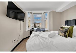 1 dormitorio con 1 cama blanca y TV en la pared en The Chill Spot: Peaceful Studio for Two, en Londres