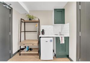 een kleine keuken met een wastafel en een koelkast bij The Chill Spot: Peaceful Studio for Two in Londen