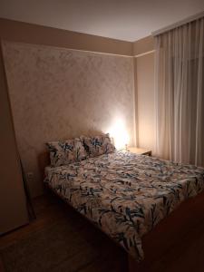 ein Schlafzimmer mit einem Bett mit einer Lampe in der Unterkunft SAN in Čačak