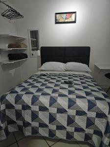 1 cama en un dormitorio con manta a cuadros en Loft lindo, acochegante e reservado en Boa Vista