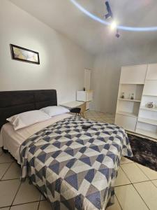 een slaapkamer met een bed en een plafondventilator bij Loft Aconchegante in Boa Vista