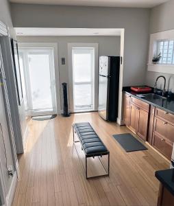 a kitchen with a black refrigerator and wooden floors at NE Portland Oregon Modern Victorian Duplex in Portland