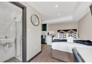 a bedroom with a large bed and a bathroom at Stay & Explore: Convenient Studio - Prime Location in London