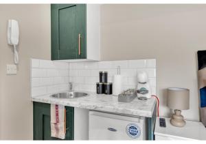 a kitchen with a sink and a counter top at Stay & Explore: Convenient Studio - Prime Location in London
