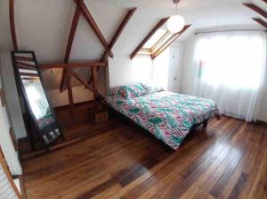 - une chambre avec un lit dans un dortoir doté de parquet dans l'établissement Loft privado Cerro Alegre, estilo Buhardilla., à Valparaíso