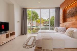 ein großes Schlafzimmer mit einem großen Bett und einem Fernseher in der Unterkunft Taman Mesari Luxury Villas-Seminyak in Seminyak