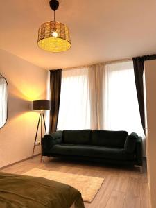 a living room with a green couch in front of a window at 93qm-4 Rooms-WiFi-City Centre in Kassel