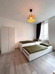 a bedroom with two beds and a chandelier at 93qm-4 Rooms-WiFi-City Centre in Kassel
