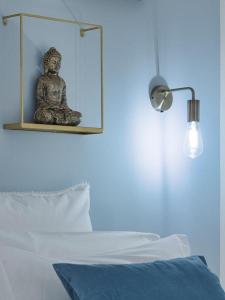 een standbeeld van een boeddha op een muur naast een bed bij Élite Suite Home in Termoli