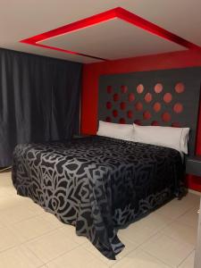 Schlafzimmer mit einem schwarzen und weißen Bett mit roten Wänden in der Unterkunft Smae in Mexiko-Stadt