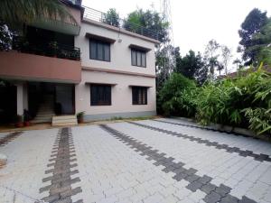 ein Haus mit einer steinernen Einfahrt davor in der Unterkunft Eve's Residency in Meppādi