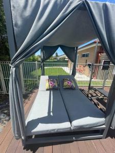 uma cama num gazebo num deque em Cosy Sunlit Home Away from Home em Baulkham Hills