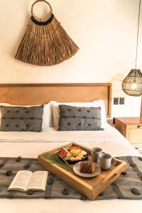 圖盧姆的住宿－NAJ TULUM，床上的盘子,有盘子的食物