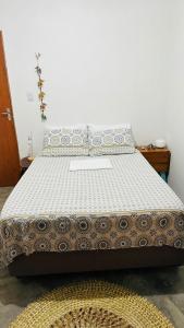 a large bed in a room with a white bedspread at Quarto Sertão no Mar in Barra do Cunhau