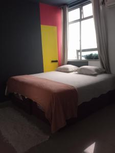 a bedroom with a large bed with a window at Pousada Márcia Elizondo in Belém